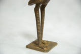 Ribbed legs and clawed feet on the square base of the bronze bird sculpture.