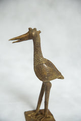 Profile view of the vintage African bronze bird's triple-horned head and textured neck.