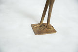 The solid bronze base and detailed webbed feet of the vintage African bird sculpture.