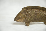 Close-up of the detailed eye and textured scales on the vintage bronze fish sculpture.