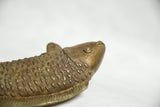 Detailed view of the African bronze fish sculpture's head, eye, and textured scales.