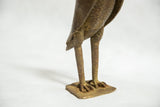 Patinated bronze legs, clawed feet, and square base of the African owl sculpture.