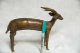Vintage African bronze antelope sculpture with spiral horns, a green Sharpie for scale.