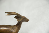 Vintage African bronze antelope sculpture head with spiral horns and aged patina.
