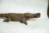 Profile view of the vintage bronze crocodile showing its textured scales and detailed head.