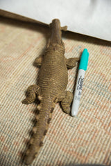 Vintage bronze crocodile sculpture from above, with a marker to illustrate its size.