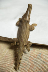 Detail of vintage African bronze crocodile sculpture, showing textured scales and spiked tail.