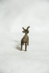 Sculpted back and haunches of a vintage bronze ram gold weight, viewed from behind.