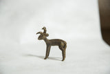 Side profile of a vintage handmade bronze ram showing its textured back and dark patina.