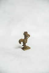 Right side profile of a vintage bronze rooster sculpture with textured armor and fanned tail.