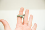 Sculptural African bronze rooster ring with a textured band, worn on a finger.