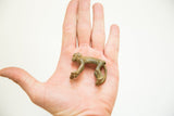 Vintage African bronze monkey showing its collectible small size in the palm of a hand.