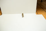 Front view of a small, stylized vintage African bronze monkey figure.