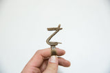 The angular, sculpted profile of a vintage African bronze pelican ring.
