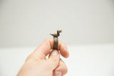 Profile of a cast bird figure on a vintage African bronze ring with a textured band.