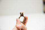 A vintage African bronze ring showing the double bird figures from the front.