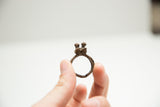 The circular band and cast bird detail of a vintage bronze African ring.