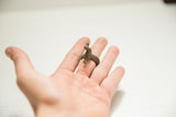 Vintage African bronze duck ring with a textured band, worn on a finger to show scale.