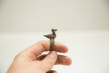 Side profile of a vintage African bronze duck ring with a textured band.