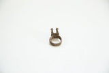Profile view of a vintage bronze ring with a textured band and two chameleon figures.