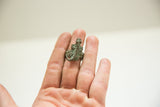 Vintage African bronze lizard ring with a textured patina, worn on a hand for scale.