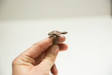 Side profile of a vintage bronze turtle ring showing the textured band.