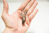Vintage African bronze rooster ring held in a palm to show its scale and side detail.