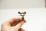 Side view of a vintage cast bronze panther ring showing its ribbed band.
