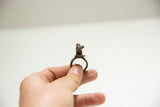 A hand holds the vintage bronze panther ring showing its scale.