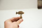Vintage bronze fish ring held to show the side profile and cross-hatched band detail.