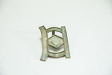 Angled view of the vintage bronze buckle showing its unique geometric form and soft patina.