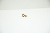 Vintage African bronze triangle charm seen from a low angle, showing its cast depth and loop.