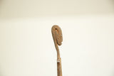 Profile detail of the vintage bronze figure's head, showing its rustic, oxidized surface.