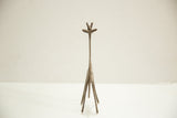 Straight-on view of a stylized bronze giraffe showing its long neck and symmetrical four-legged stance.