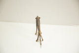 A vintage African bronze lion showing its textured spine and splayed legs from behind.