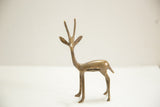 Aged bronze African gazelle figure, detailed with slender body and ribbed horns.