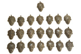 A collection of vintage African bronze face pendants showing a variety of unique designs and patina.