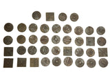 An assortment of vintage round and square African bronze coins with varied geometric patterns.