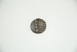 Collectible African bronze coin with dark patina, featuring distinct spiral and striped patterns.