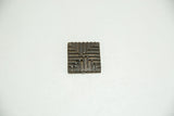 Bronze coin with raised geometric labyrinth pattern and dark, time-softened patina.