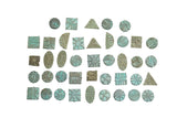 A collection of small vintage bronze African coins showing various shapes with a green oxidized patina.