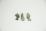 A group of vintage African bronze pendants with varied patinas and figurative designs.
