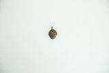 Front view of a tiny African bronze face pendant highlighting its vintage patina.