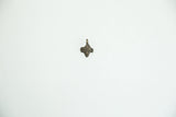 A single tiny African bronze face pendant shown for scale.