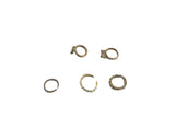A selection of one-of-a-kind vintage African bronze rings with varied, textured designs.