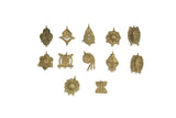 An assortment of vintage African bronze pendants, each with a unique, handcrafted geometric design.