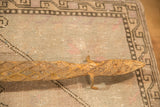 Vintage iron lizard sculpture head with diamond pattern, rich patina, on a soft geometric rug.