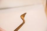 Curved body of the vintage iron snake sculpture, showing textured patina.