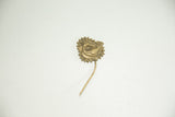 The complete vintage bronze bird pin, showing the textured roundel and long, slender pin stem.