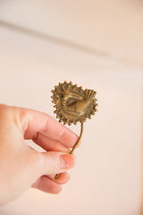 Vintage bronze bird pin held in hand to demonstrate its scale and warm patina.